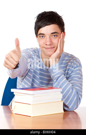 Glückliche Schüler sitzen am Schreibtisch mit Büchern und zeigt Daumen oben. Isoliert auf weißem zuzuordnen. Stockfoto