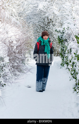 Frau zu Fuß entlang einer Schnee bedeckten Strecke in Redditch, Worcestershire. Stockfoto