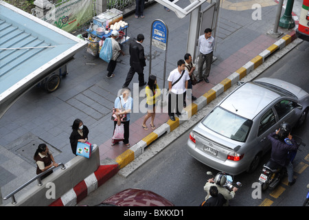 Menschen warten an der Bushaltestelle in Bangkok Stockfoto