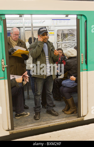 Telefonieren mit Handy an Tür von Paris u-Bahn PKW Stockfoto