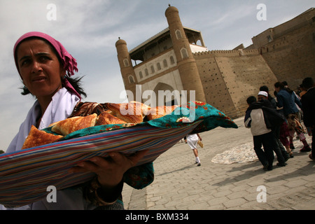 Usbekische Frau verkauft Samsa vor dem Eingang zur Festung Ark Registan-Platz in Buchara, Usbekistan. Stockfoto