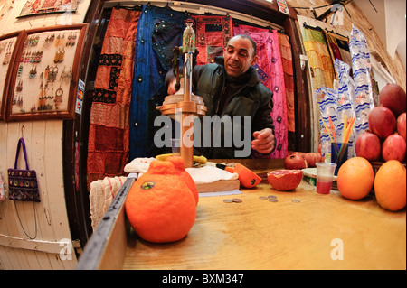 Israel, Akko. Safthändler quetscht Orangen in der Altstadt von Akko auf dem arabischen Markt. Stockfoto