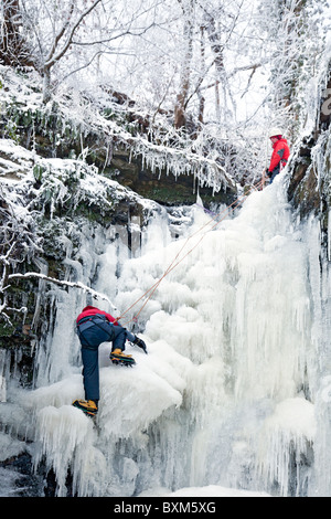 Kletterer tun ein Eis klettern auf einem gefrorenen Wasserfall (Lynn fällt) in North Ayrshire, Schottland, Großbritannien Stockfoto