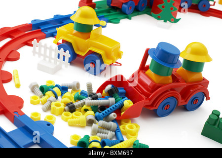 Die Spielzeug-Planierraupe und die Eisenbahn auf weißem Hintergrund Stockfoto