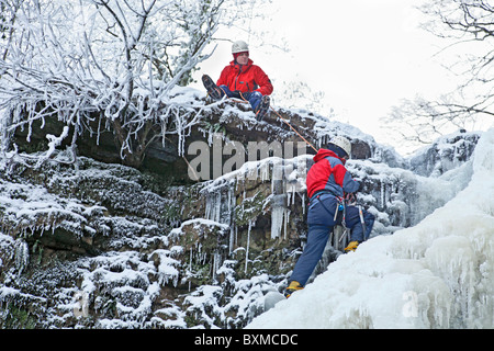 Zwei Bergsteiger am Ende des Eises Klettern auf einem gefrorenen Wasserfall (Lynn fällt) außerhalb Dalry in North Ayrshire, Schottland, Vereinigtes Königreich. Stockfoto