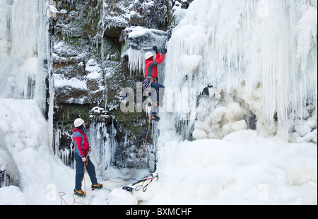 Zwei Männer auf einem Eis klettern auf einem gefrorenen Wasserfall (Lynn fällt) außerhalb Dalry in North Ayrshire, Schottland, Vereinigtes Königreich. Stockfoto