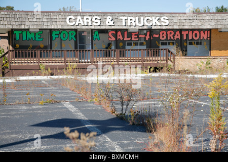 Verlassene Pkw- und LKW-Händler Baulücke mit Unkraut. Schild steht Zeit für einen Verkauf ein Bration. Stockfoto