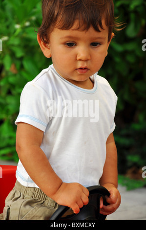 Porträt von einem 1 Jahr alten Jungen in Spielzeugauto Stockfoto