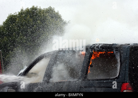 Ein Auto Feuer mit Flammen Wasser Spray und Dampf Stockfoto