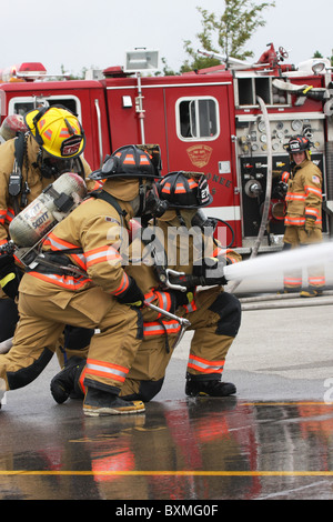 Feuerwehrleute auf einem Neuanschluß ein Löschangriff Stockfoto