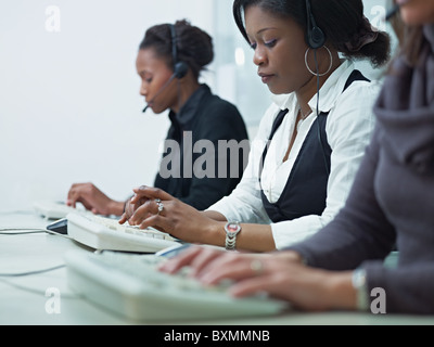 multiethnische Gruppe von weiblichen Kundenservice am Telefon sprechen und schreiben auf der Computertastatur. Stockfoto