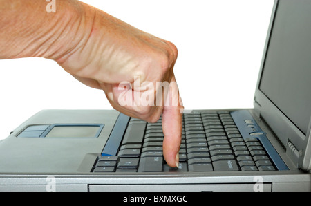 Ein Zeigefinger einer Hand drücken die Enter-Taste auf einem Laptopcomputer. Stockfoto