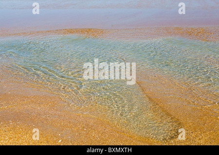 Abstrakte Nahaufnahme von Agua farbige flache Wasserlachen am Strand am Rande des Atlantischen Ozeans Stockfoto