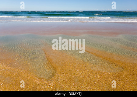 Abstrakte Nahaufnahme von Agua farbige flache Wasserlachen am Strand am Rande des Atlantischen Ozeans Stockfoto