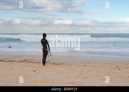 Einsame männliche Surfer betrachtet den Ozean am Bondi Beach in Sydney, Australien Stockfoto