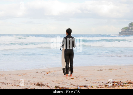 Einsame männliche Surfer betrachtet den Ozean am Bondi Beach in Sydney, Australien Stockfoto