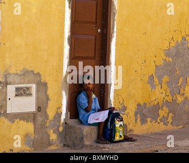 Schulkind ruht auf einer Türschwelle, Sal Rei, Boa Vista, Kap Verde Stockfoto