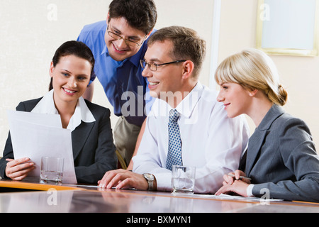 Team von vier erfolgreichen professionellen versammelt am Tisch sprechen über ihre Ergebnisse der Arbeit Stockfoto