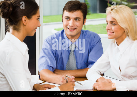 Drei junge Fachleute versammelt am Tisch diskutieren wichtiges Projekt Stockfoto