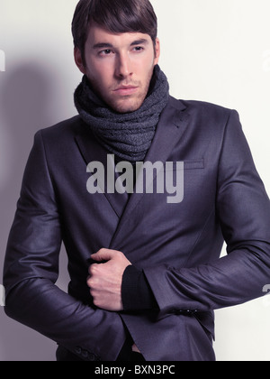 Mode-Porträt eines jungen Mannes trägt einen schwarzen Blazer und einen Schal isoliert auf weißem Hintergrund Stockfoto