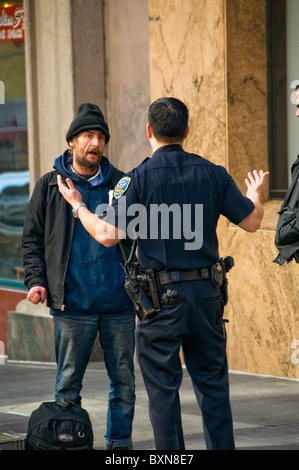 Obdachloser auf Stadtstraße in San Francisco CA im Gespräch mit Polizist Stockfoto