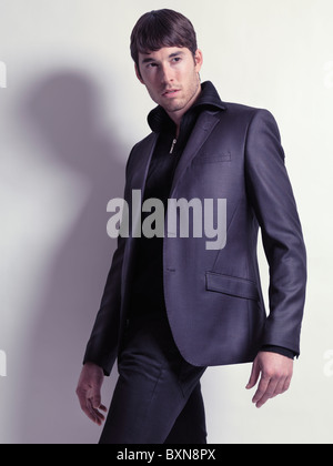 Mode-Porträt eines jungen Mannes trägt einen schwarzen Blazer isoliert auf weißem Hintergrund Stockfoto