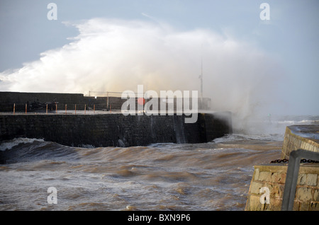 Wellen von einem großen Sturm schlägt im Hafen von Aberaeron an einem kalten Dezember-Morgen ist Wich ein sicherer Hafen für Boote Stockfoto