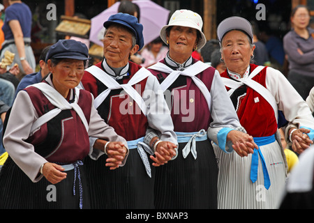 Naxi Frauen tanzen in Straße, Lijiang, Provinz Yunnan, China Stockfoto