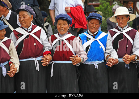 Naxi Frauen tanzen in Straße, Lijiang, Provinz Yunnan, China Stockfoto