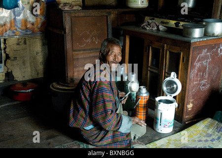 In der Küche seiner Heimat in Bhutan Bauernhaus bereitet der Familie Patriarch eine Thermoskanne mit Tee Stockfoto