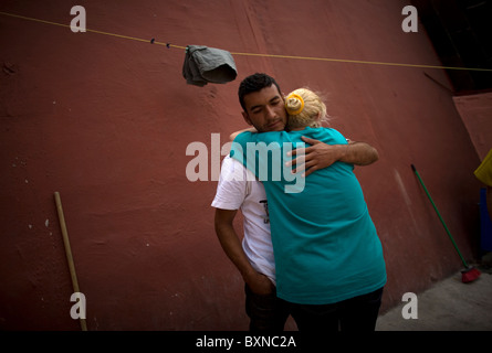 Eine Frau schmiegt sich an ihren Sohn, zentralamerikanischen Migranten quer durch Mexiko reisen, arbeiten in den Vereinigten Staaten in Mexiko-Stadt Stockfoto