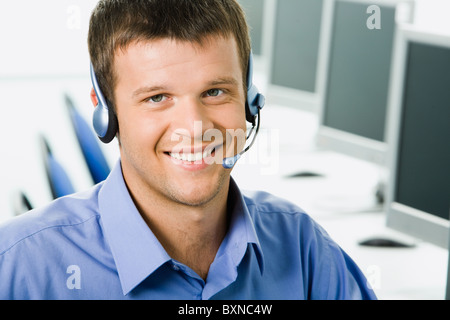 Freundliche Telefonistin lächelnd während eines Telefongesprächs Stockfoto