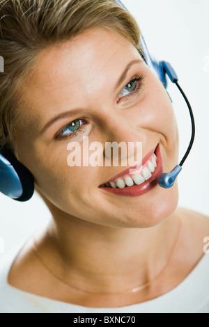 Nahaufnahme der jungen attraktiven lächelnd Geschäftsfrau spricht über die Kopfhörer Stockfoto