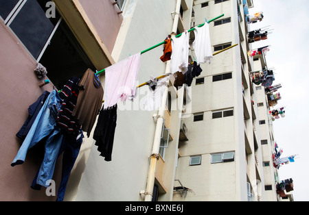 Singapur, das Waschen ist oft aus dem Fenster auf einem Stick Trocknen aufgehängt. Stockfoto