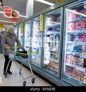 Eine Frau mit einem Trolley Einkaufen von Lebensmitteln in einem Zweig der Morrissons Supermarkt, UK Stockfoto