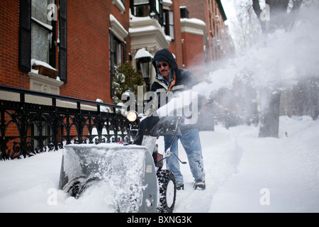 Ein Mann nutzt eine Schneefräse, um einen Bürgersteig nach massiver Schneefall in Brooklyn, New York zu löschen. Stockfoto