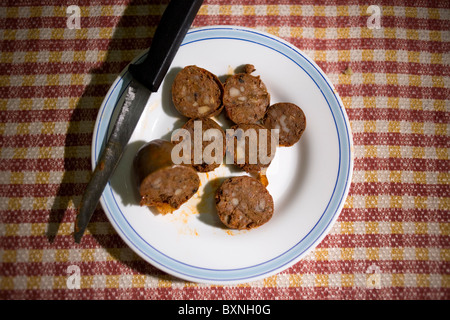 Blut-Wurst gemacht aus Spanisch-iberische Schweine auf einem Teller in einem Heim in Prado del Rey, Sierra de Cadiz, Spanien sitzen. Stockfoto