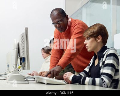 Computer-Klasse mit indischen Lehrer Studentin zu helfen. Horizontale Form, Seitenansicht, Hüfte aufwärts Textfreiraum Stockfoto