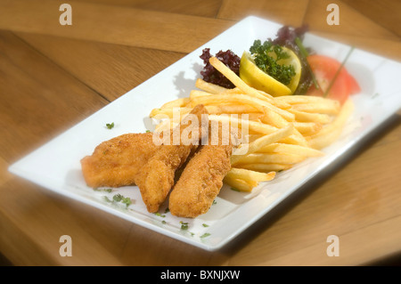 Fry Fischstäbchen w Zitrone Tomate und Kartoffel-chips Stockfoto