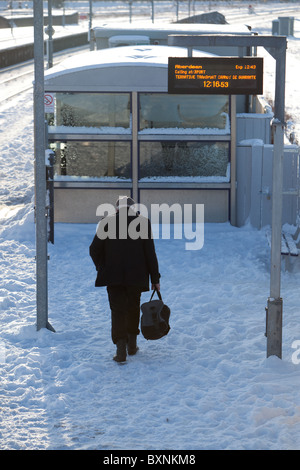 Flugreisenden für Zugverbindung auf verschneiten Plattform Montrose Schottland Stockfoto