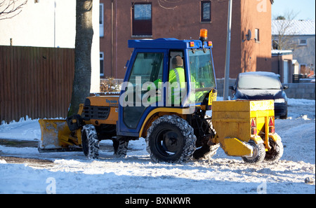 Die Schneeräumung durch den Rat. Montrose. Splitt verteilen und Schnee von Gehwegen pflügen Stockfoto