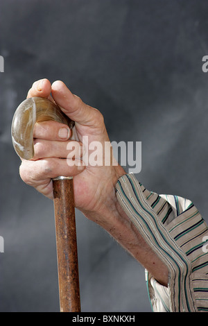 Obdachloser Mann hält einen Spazierstock Stockfoto