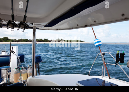 Tropische Insel, gesehen von der Rückseite Deck eines luxuriösen Katamaran Yacht während vor Anker in den Indischen Ozean Archipel Mosambiks unter blauen Himmel Stockfoto