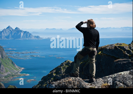 Wanderer genießt die Aussicht vom Gipfel des Justadtind, Lofoten Inseln, Norwegen Stockfoto