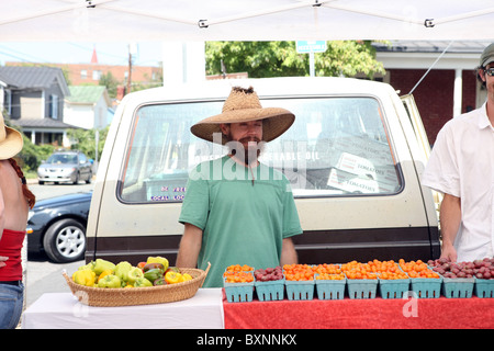 Ein Mann wartet wie vermischen sich Kunden über den Bauernmarkt in Charlottesville, VA. Stockfoto