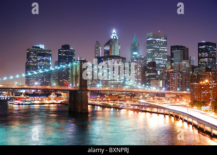 Skyline von New York City Manhattan und Brooklyn Bridge mit Wolkenkratzern über Hudson River mit Lichtern und verkehrsreichen beleuchtet Stockfoto