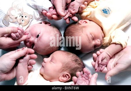 Neugeborene Tag alte Babys mit ihren Müttern Händen auf einer Entbindungsstation Stockfoto