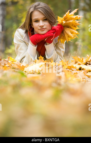 Foto von ruhenden junge Frau liegend auf Laub im Herbst Stockfoto