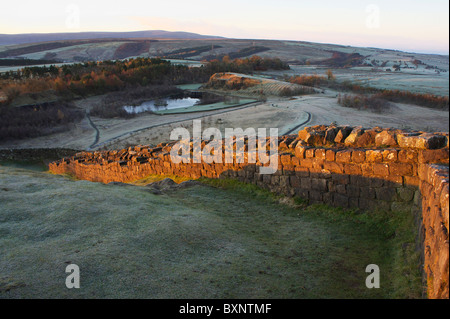 Winter-Sonnenaufgang am frostigen Morgen am Hadrianswall an der Spitze der Walltown Felsen Stockfoto