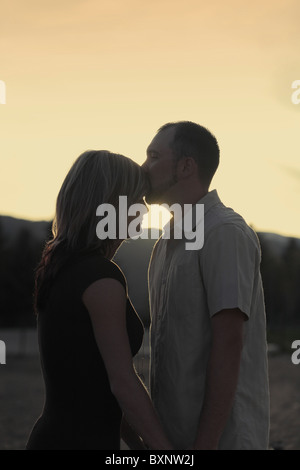 Silhouette der Mann küsst Frau Stirn bei Sonnenuntergang Stockfoto